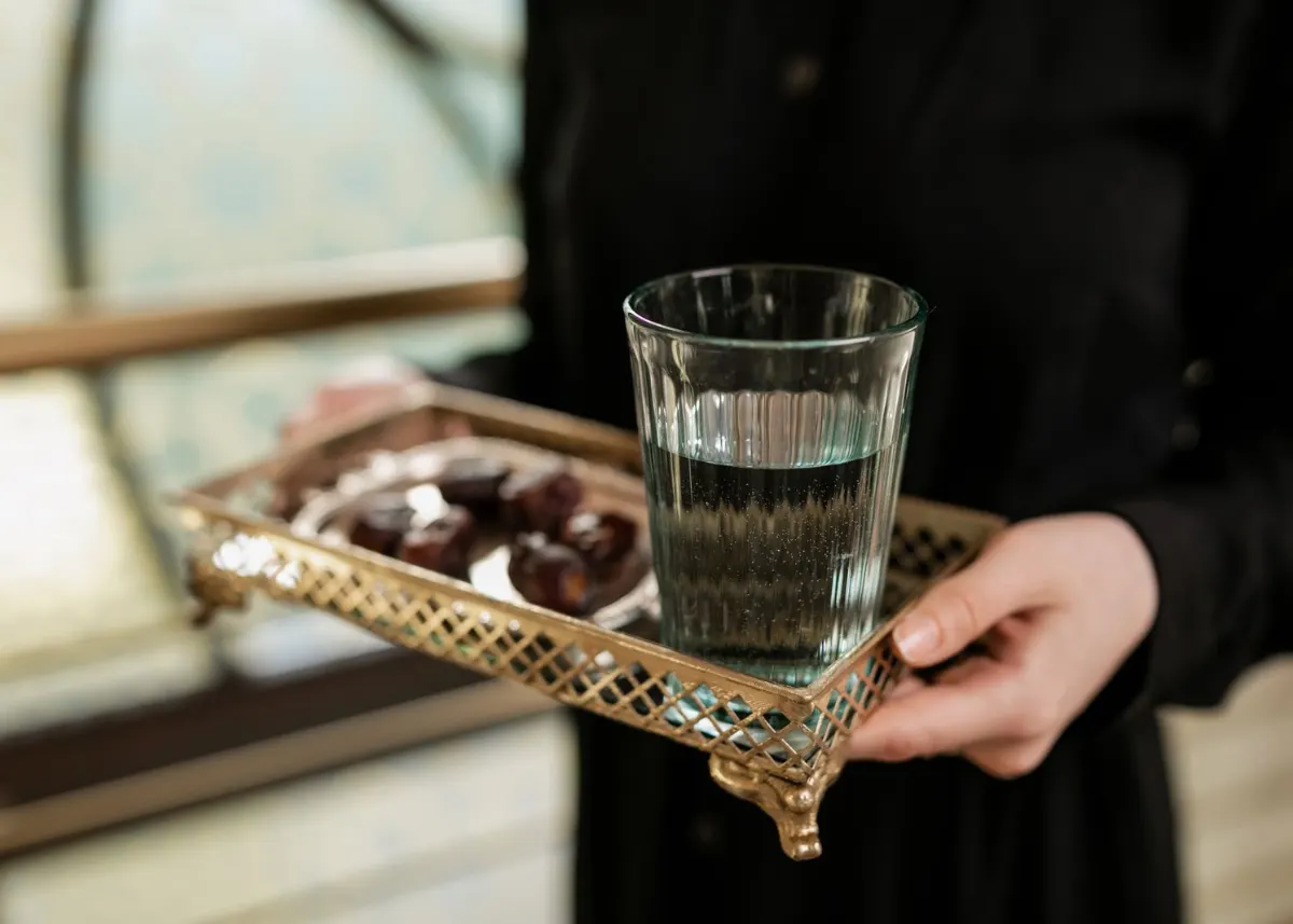 A glass of water and dates on a tray, ready to open the fast