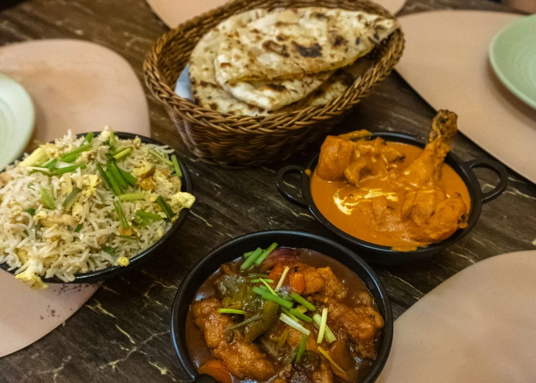 Restaurant table set with naan, rice and curry, the kind of meal out DHA clients plan around