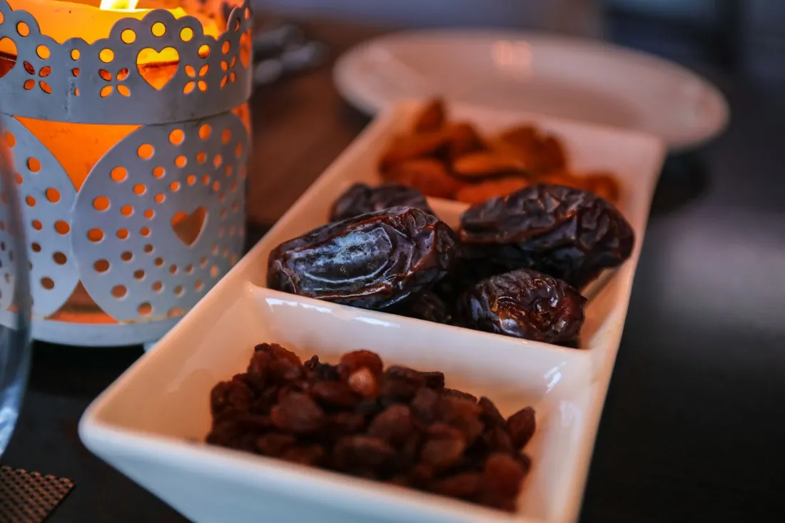Dates served in white dishes beside a Ramadan lantern, for iftar planning with PCOS