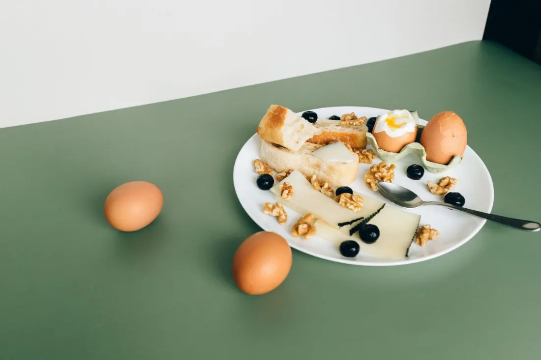 Plate of boiled eggs, cheese, bread and walnuts, everyday kitchen protein instead of imported supplement powder