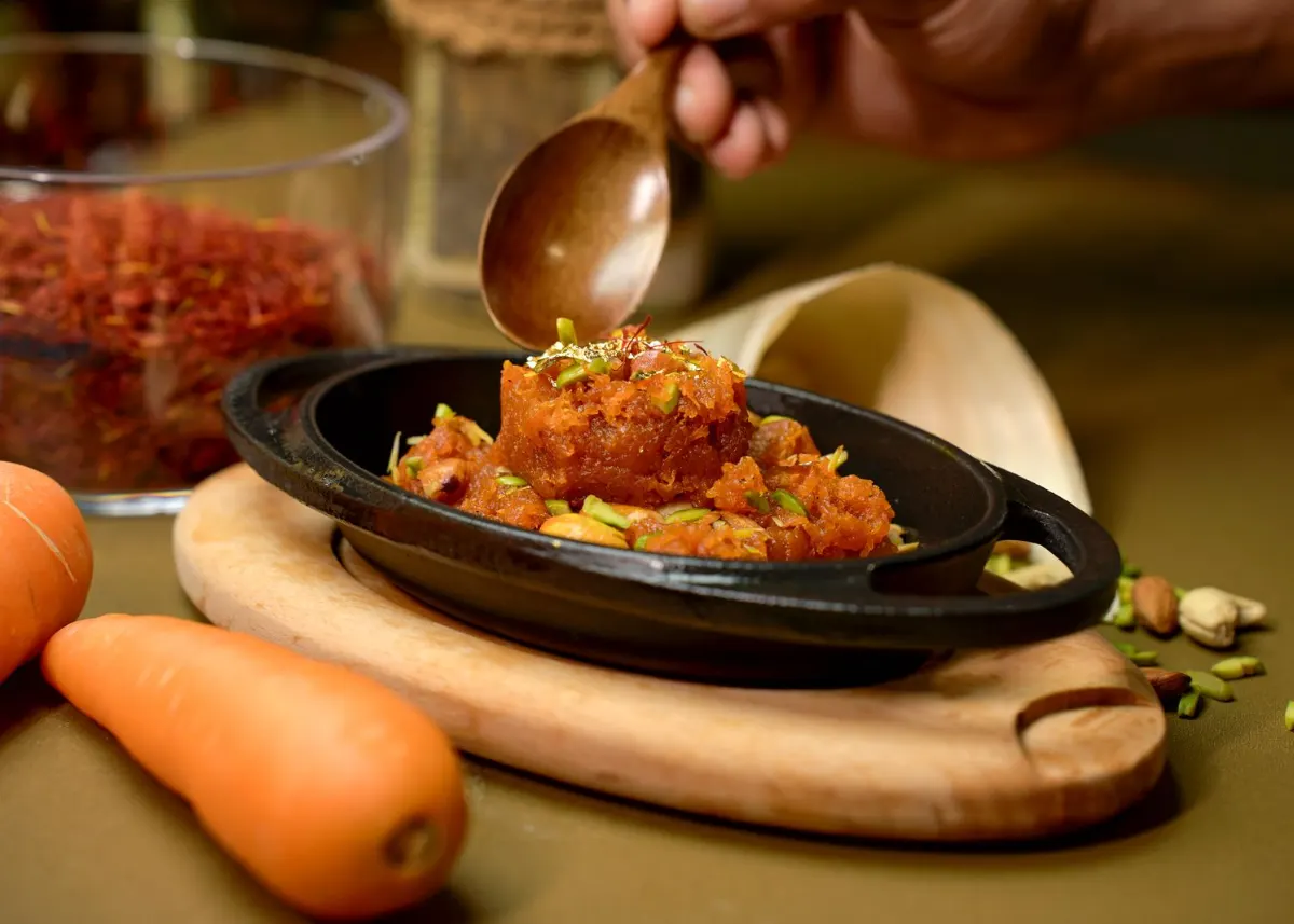 Gajar halwa in a serving dish with fresh carrots