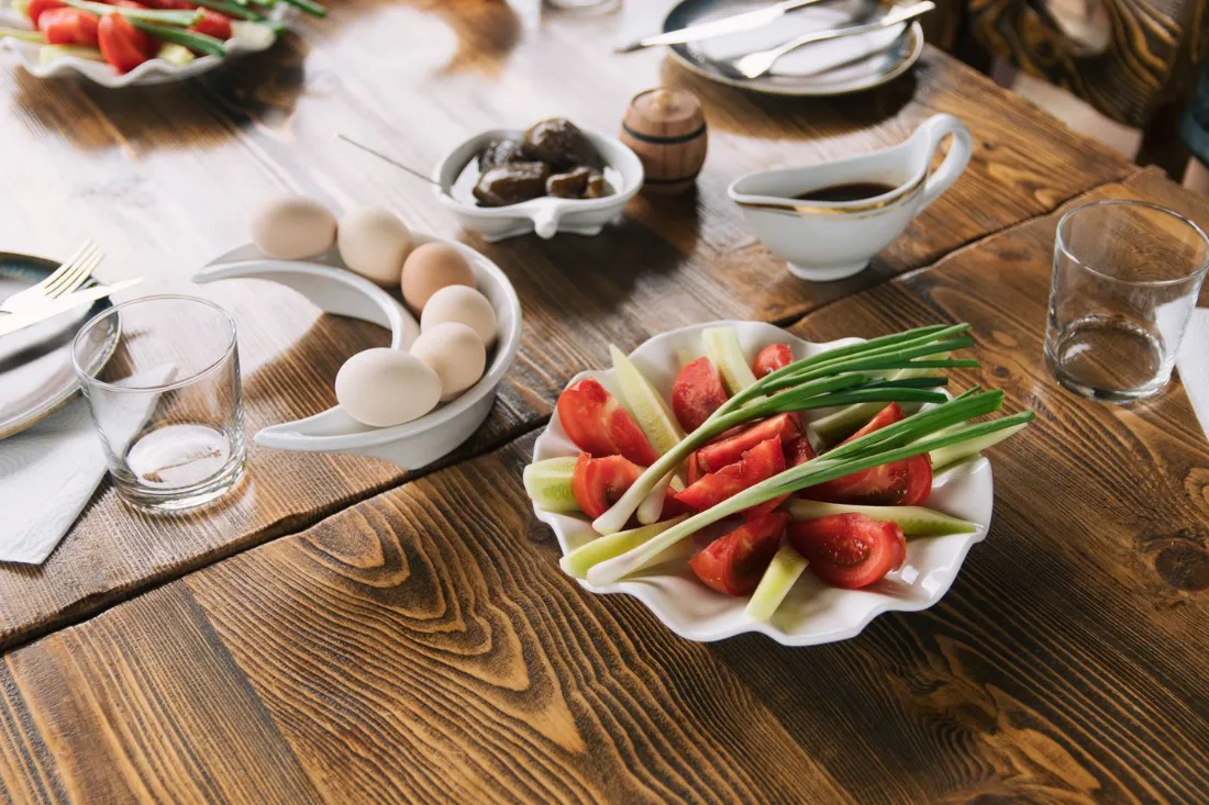 Suhoor table set with boiled eggs, tomatoes, spring onions and glasses of water before a day of fasting